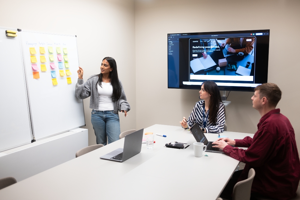 3 People looking at a whiteboard with smile