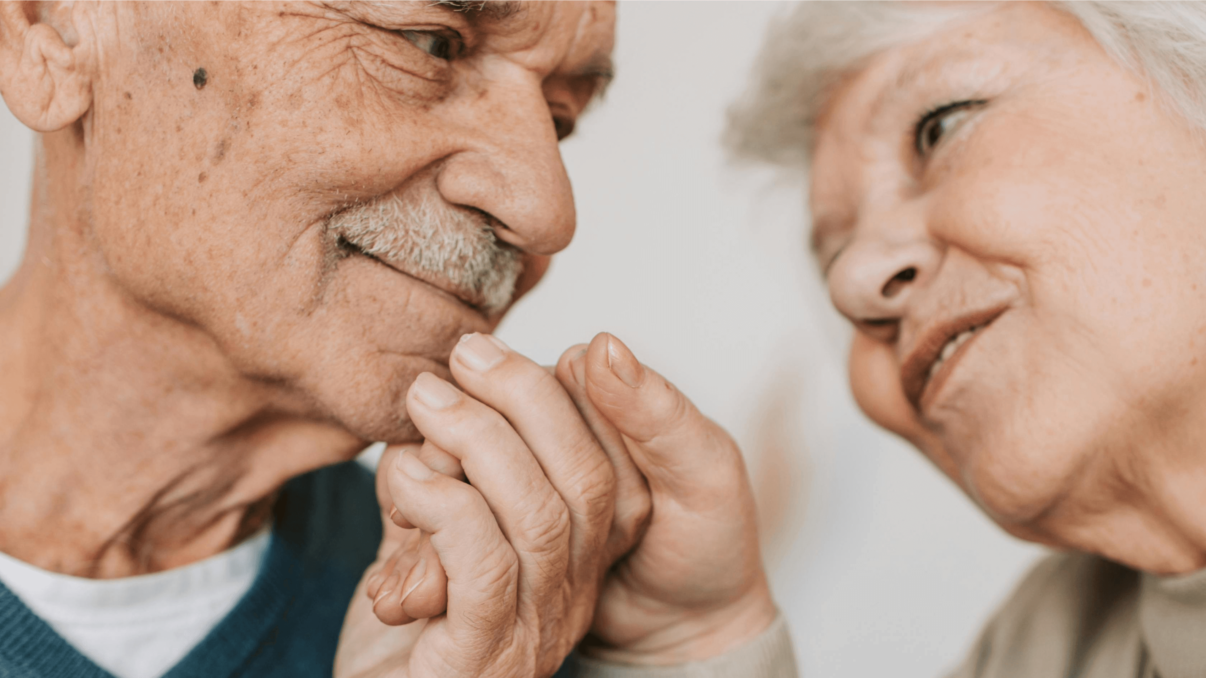 Close up image of a couple holding hands looking at each other